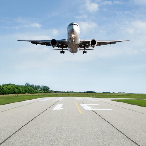 jet airplane landing on runway with bright sky (XL)